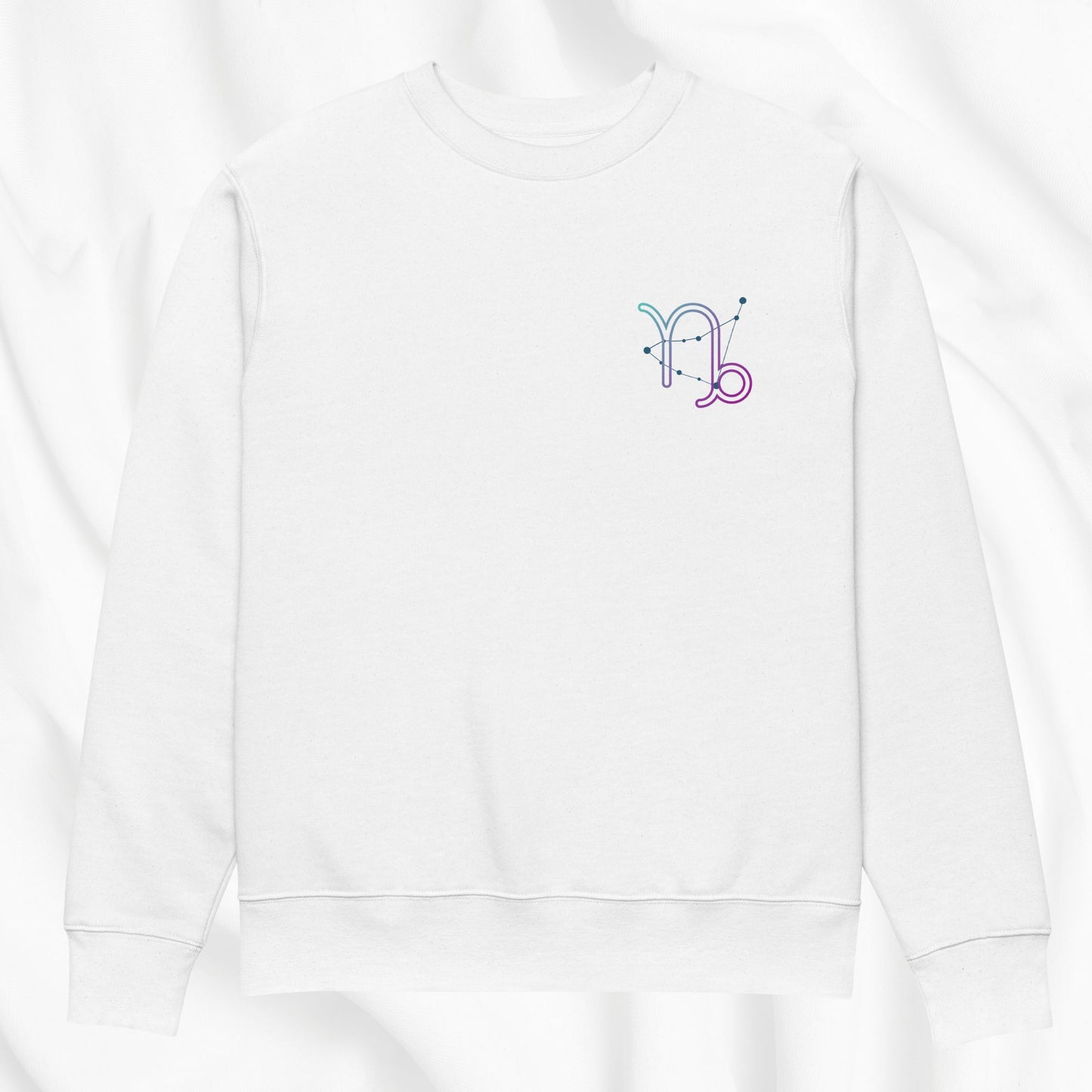 White hoodie with a colorful Capricorn design on the chest against a white background