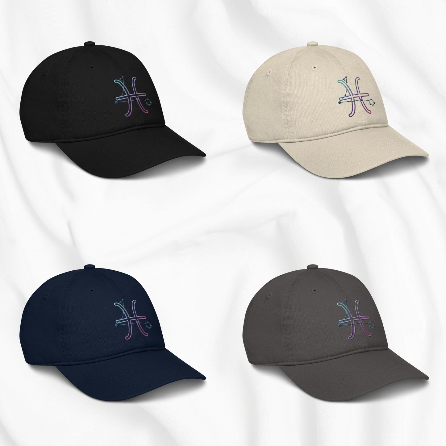 Four baseball caps in black, beige, navy, and gray with an embroidered pisces zodiac design on a white background