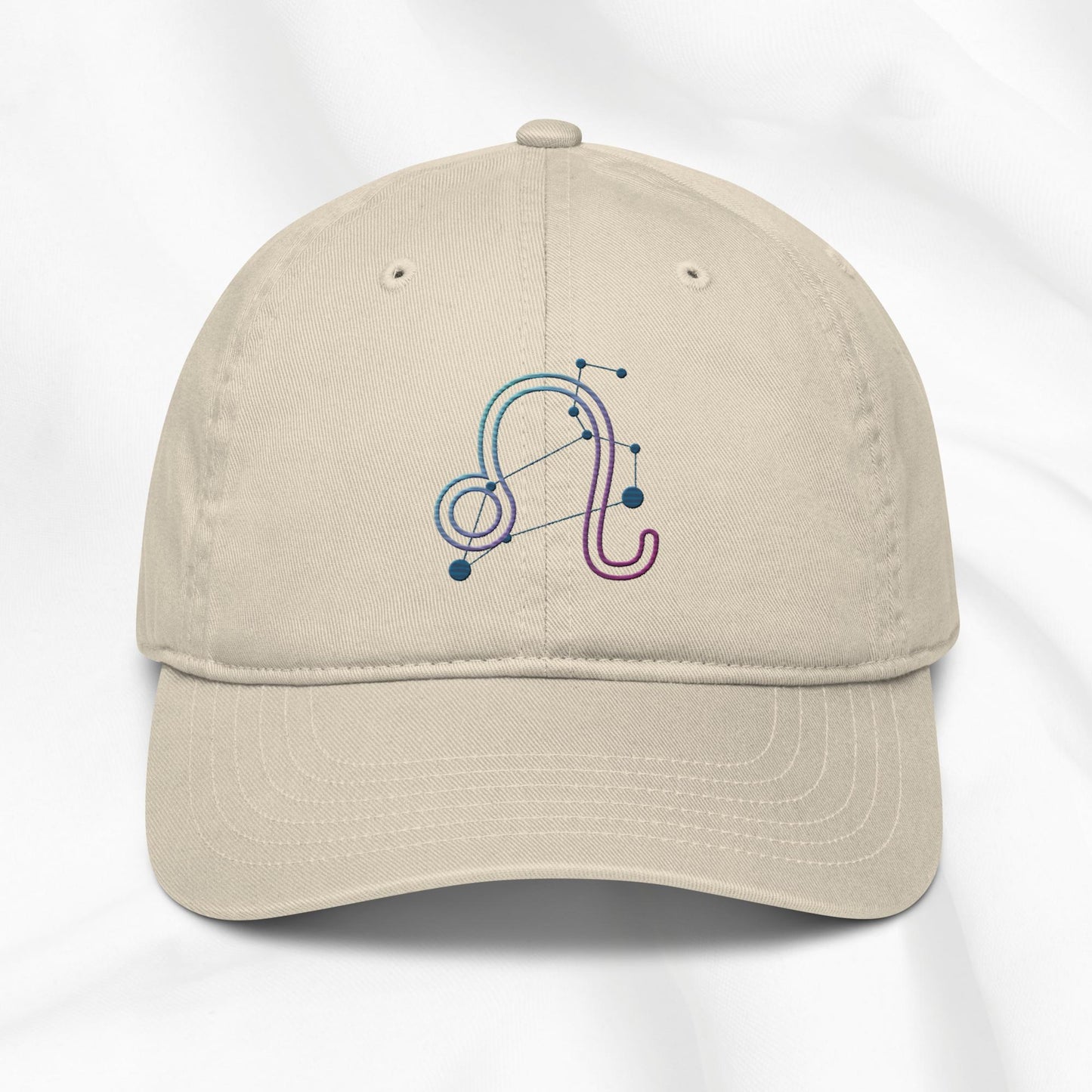 Beige organic cotton baseball cap with embroidered Leo zodiac design on a white background