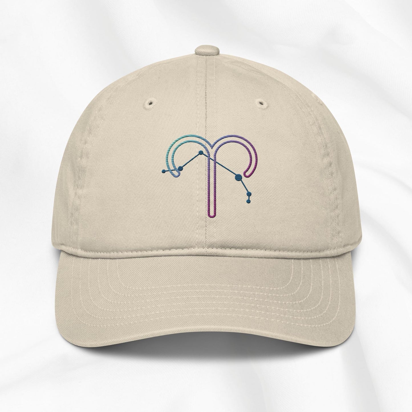 Beige organic cotton baseball cap with an embroidered Aries zodiac design on a white background