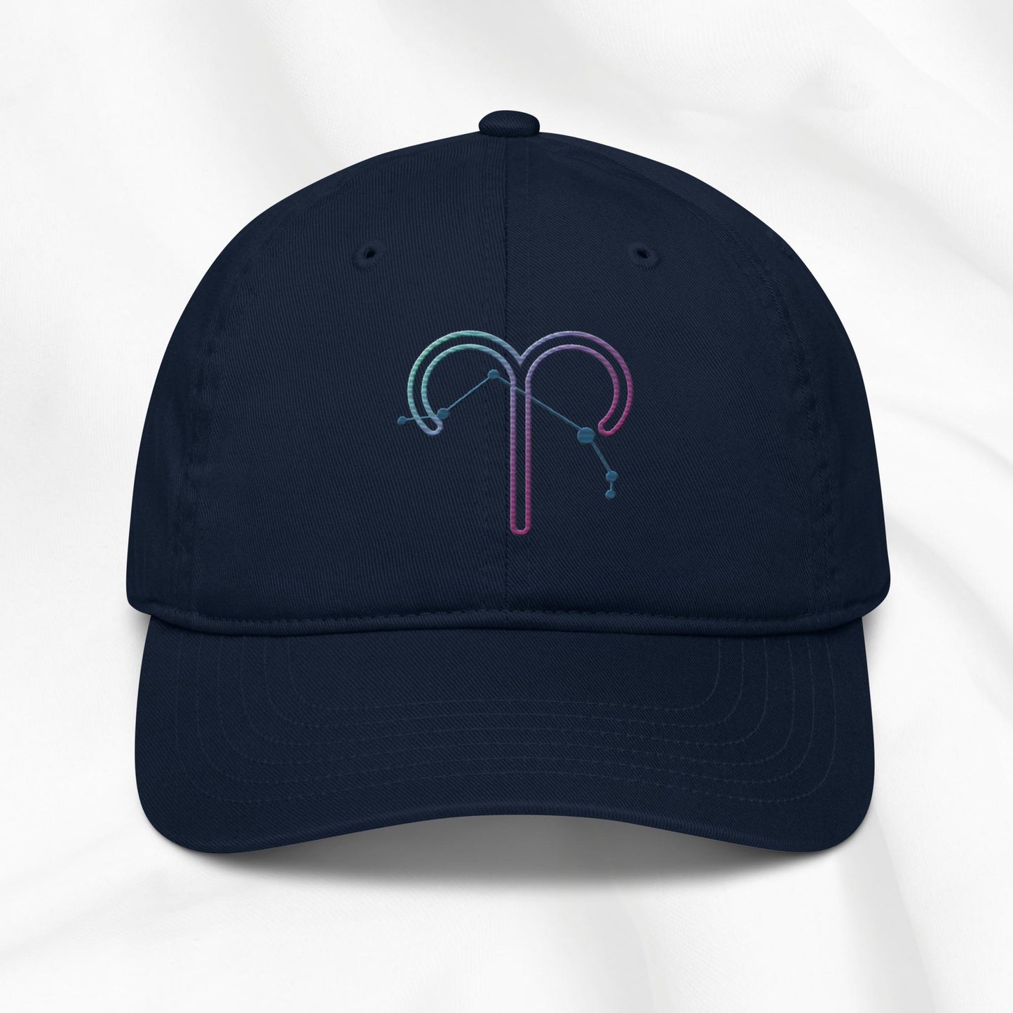 Navy organic cotton baseball cap with an embroidered Aries zodiac design on a white background