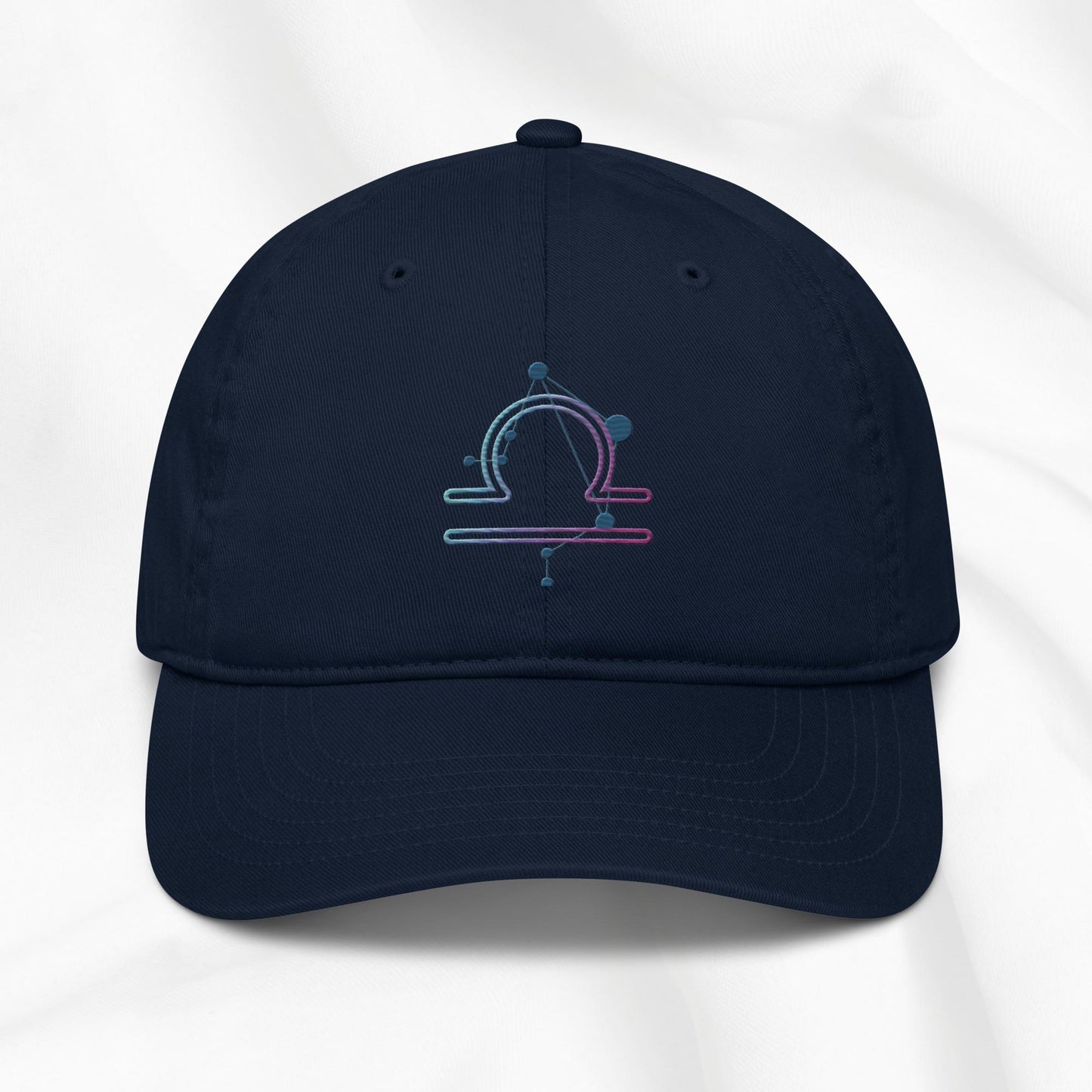 Navy organic cotton baseball cap with an embroidered libra zodiac design on a white background