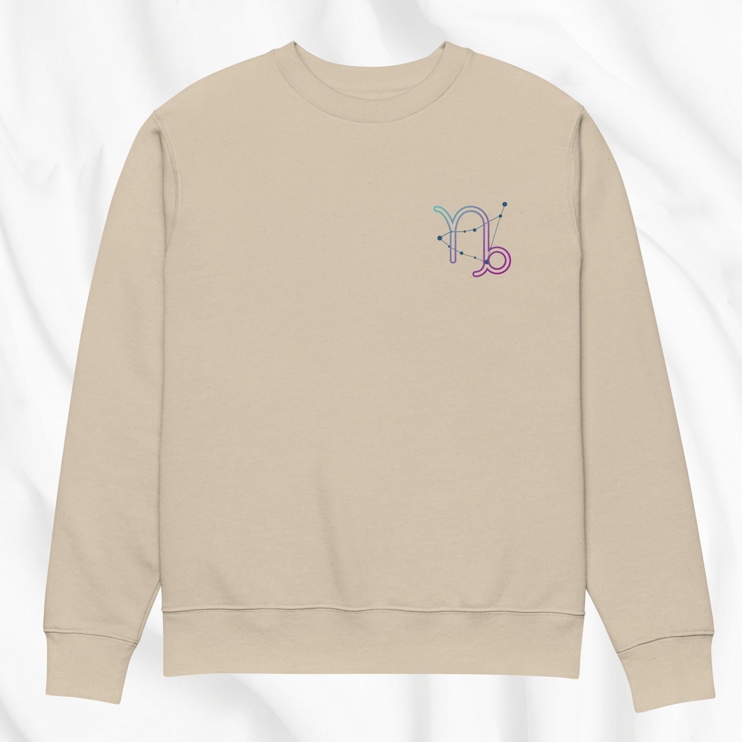 Beige sweatshirt with a colorful Capricorn design on a white background