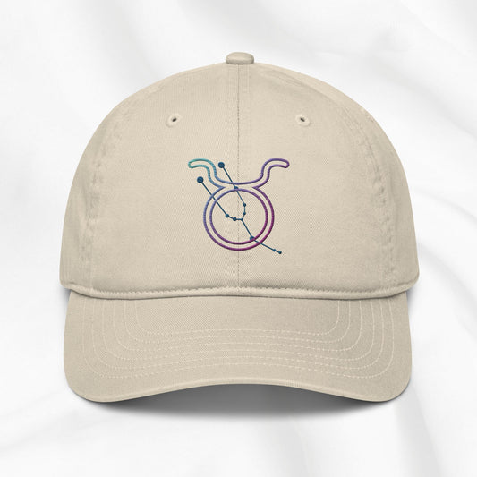 Beige cap with a colorful embroidered Taurus zodiac symbol on a white background