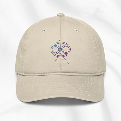 Beige organic cotton baseball cap with embroidered Cancer zodiac graphic on a white background
