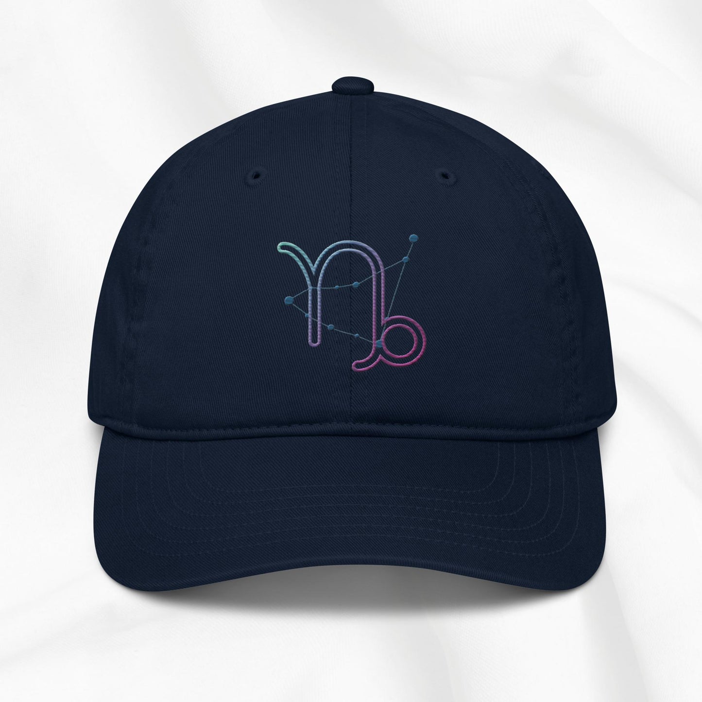 navy organic cotton baseball cap with embroidered capricorn graphic on white background