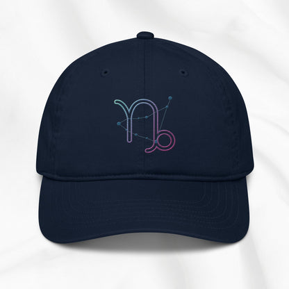 navy organic cotton baseball cap with embroidered capricorn graphic on white background