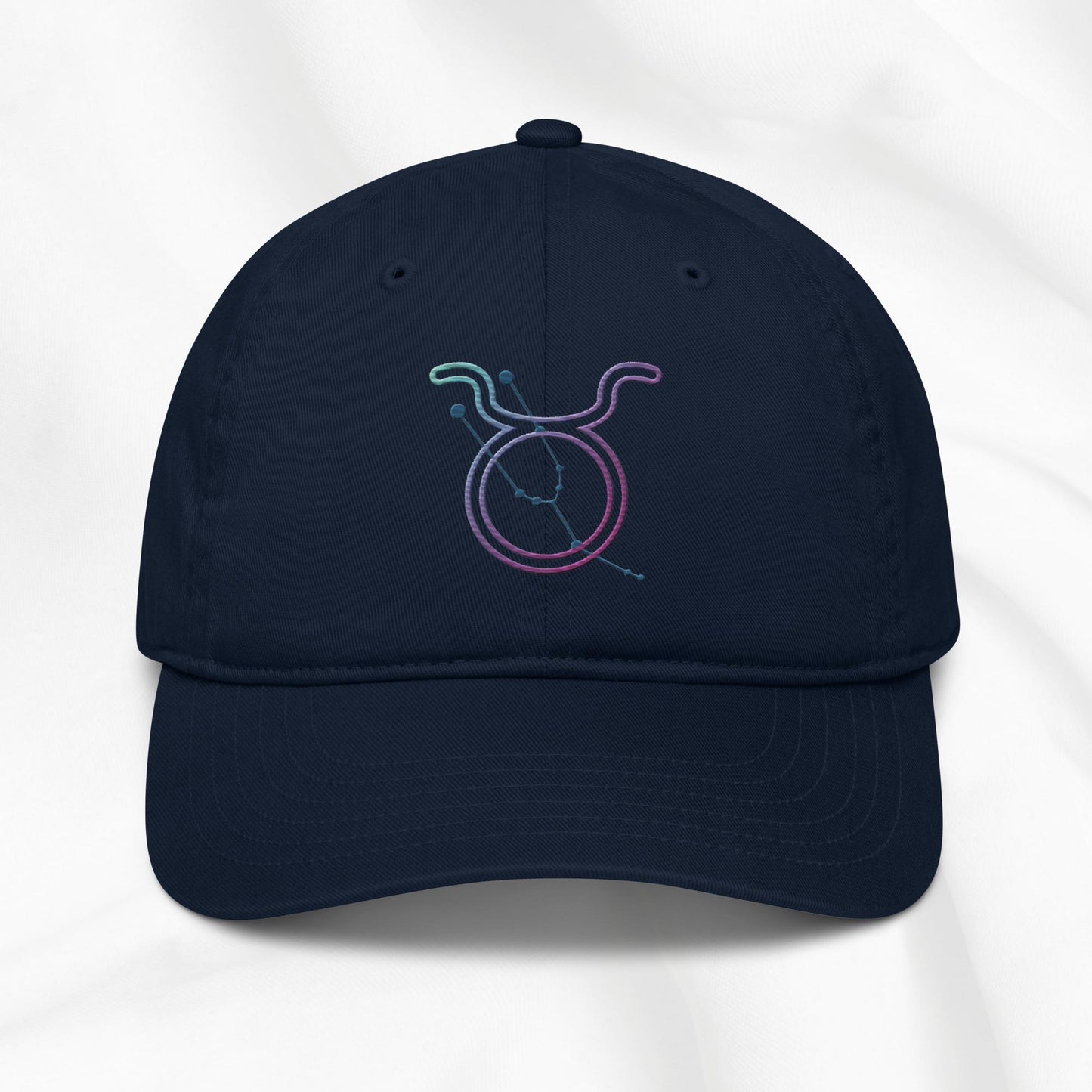 Navy baseball cap with a colorful embroidered Taurus zodiac symbol on a white background