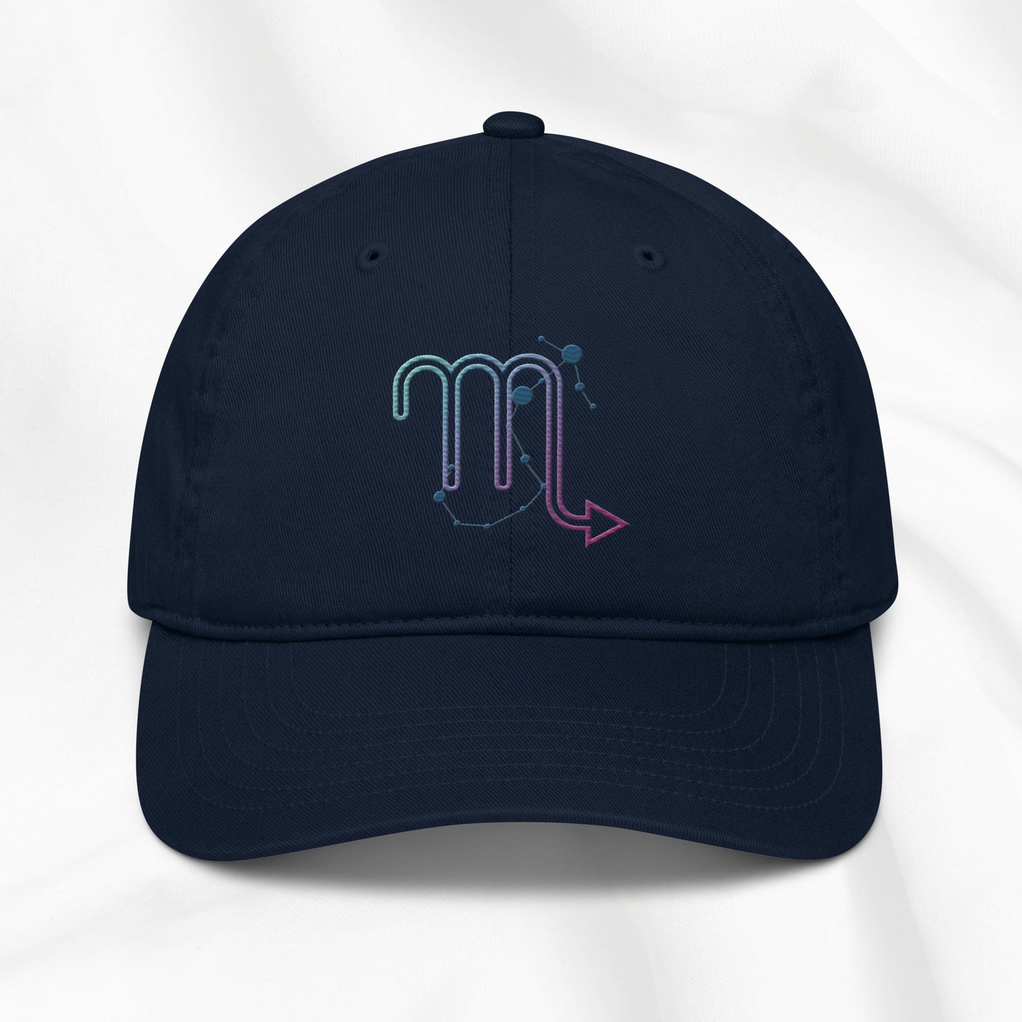 Navy organic cotton baseball cap with an embroidered scorpio zodiac graphic on a white background. 