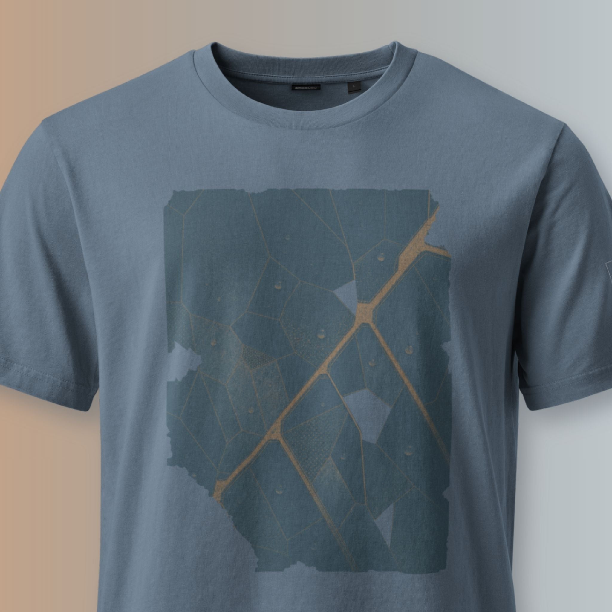 Close-up of the Veinwork abstract leaf-vein graphic printed on the Deep Teal organic cotton T-shirt.