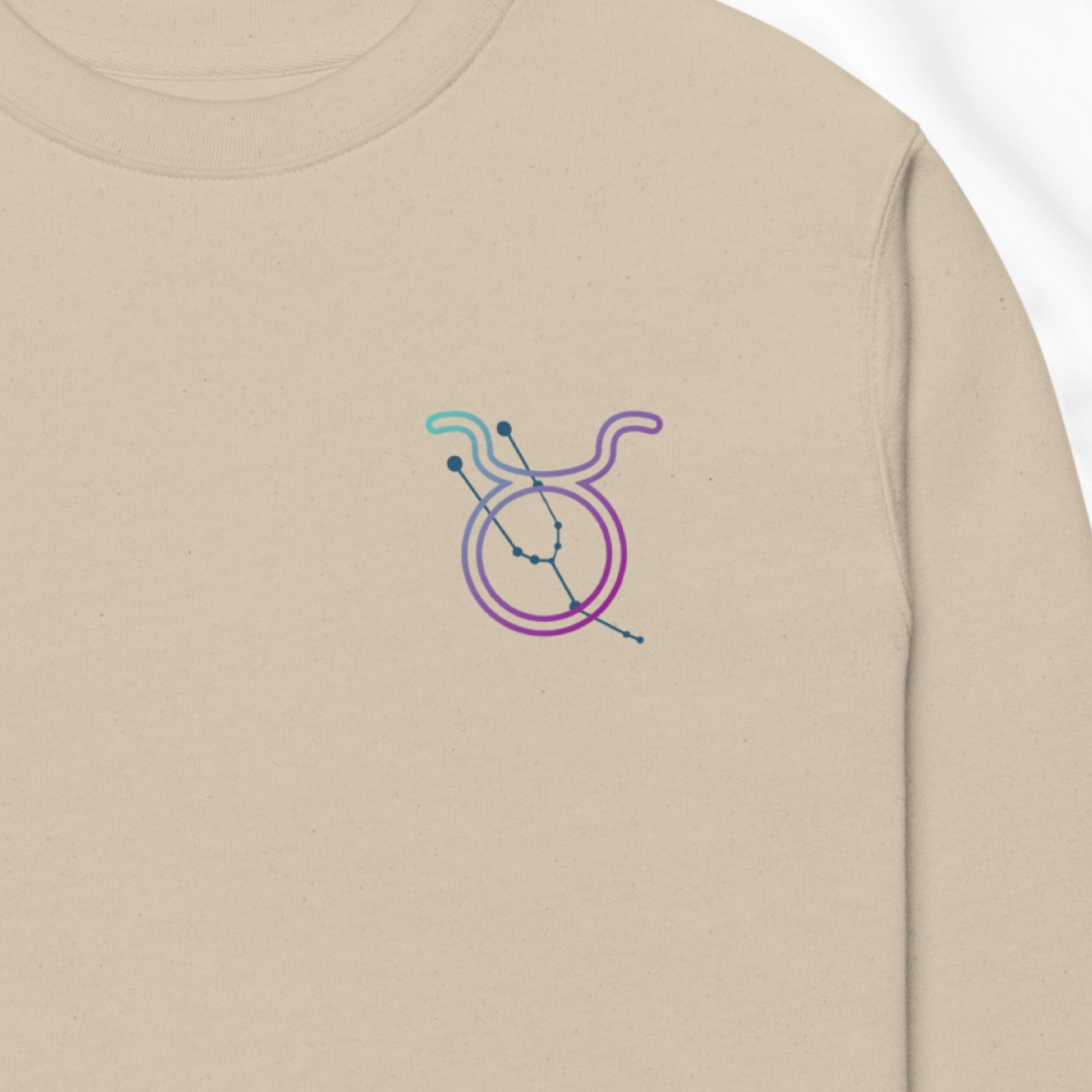 Beige sweatshirt with a colorful embroidered design on the chest.